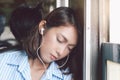 Relax time of asian young woman sleeping and listening music in earphones during trip on the train Royalty Free Stock Photo