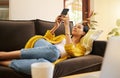 Relax woman on her phone with social media while on the sofa in house. Content female browsing internet with app while Royalty Free Stock Photo