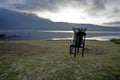 Relax woman sitting alone on a wooden chair, enjoying peaceful morning in the lake. self reflection and contemplation concept. Royalty Free Stock Photo