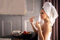 Relax woman in white towel sitting on bar counter breakfast at luxury home hotel apartment back view Royalty Free Stock Photo