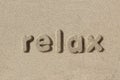 Relax written in sand letters