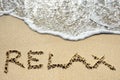 Relax written on sandy beach near sea - holiday concept Royalty Free Stock Photo