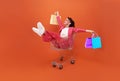 Relax young woman lying in shopping cart and hand holding shopping bag