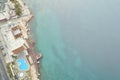 Relaxation area with swimming pool and beach umbrellas at the sea coast. Top down aerial view Royalty Free Stock Photo