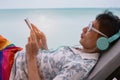 Asian man Freelance working and check email by mobile phone which on line working in a vacation summer concept on the beach Royalty Free Stock Photo