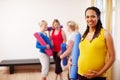 Relaxation exercise is perfect for pregnancy. A happy young pregnant African-American woman holding her exercise mat Royalty Free Stock Photo