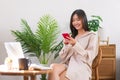 Relaxation lifestyle concept, Young Asian woman use smartphone to chatting after working at home Royalty Free Stock Photo