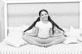 Relaxation and meditation. Girl child sit on bed in her bedroom. Kid prepare to go to bed. Pleasant time for evening Royalty Free Stock Photo