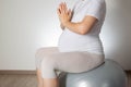 Relaxation and meditation for a pregnant girl on a fitball ball on a white background. Women Health. Copy space for text