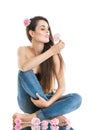 Relaxation, meditation. Young beautiful woman sitting on the floor in jeans. The girl holds a rose in hands.