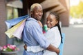 Relaxation after shopping. Smiling african american couple with colored bags walking home after shop Royalty Free Stock Photo