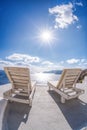 Relaxation on sunbeds against sunset in Oia village, Santorini island, Greece Royalty Free Stock Photo