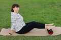 Relaxation after workout. Happy adult sportive woman in casual sportswear works out the fascia of the back muscles of