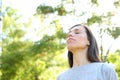 Relaxed adult woman breathing fresh air in a forest