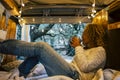 Relaxed adult woman inside a vintage wooden van enjoy the natoure outdoor and the travel lifestyle - tourist and vehicle camping