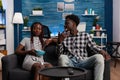 Relaxed african american friends sitting on sofa and talking Royalty Free Stock Photo