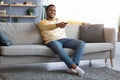 Relaxed african american guy switching channels on TV Royalty Free Stock Photo