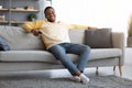 Relaxed african american guy switching channels on TV Royalty Free Stock Photo