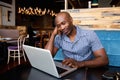 Relaxed african man at a cafe table using laptop Royalty Free Stock Photo