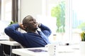 Relaxed Afro American business man sitting at his desk looking into the air. Royalty Free Stock Photo