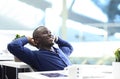 Relaxed afro american business man sitting at his desk looking into the air Royalty Free Stock Photo