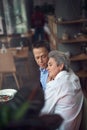 Relaxed aged couple enjoying dinner in cafe