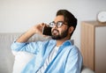 Relaxed Arab Man Talking On Celphone While Resting On Couch At Home Royalty Free Stock Photo