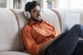 Relaxed arab man watching movile on laptop, home interior Royalty Free Stock Photo