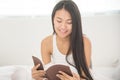 Relaxed Asian girl reading a book.