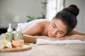 Relaxed Asian woman lying on massage table with eyes closed, waiting for Thai massage Royalty Free Stock Photo