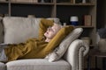 Relaxed asleep elderly homeowner woman resting on couch Royalty Free Stock Photo