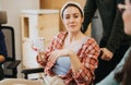 Relaxed atmosphere as a young female employee enjoys a break with a mug, sharing a moment of joy with colleagues.