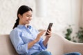 Relaxed japanese woman chilling at home, using smartphone Royalty Free Stock Photo