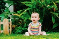 Relaxed baby enjoying the sensation of noticing the freshness of the grass on his bare feet