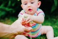 Relaxed baby enjoying the sensation of noticing the freshness of the grass on his bare feet