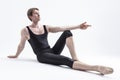 Relaxed Ballerino Dancer Sitting While Practising Stretching Exercices Before Training In Black Sportive Tights in Studio