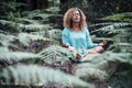Relaxed beautiful lady do meditation sitting in the middle of nature plant outdoor - people in mindfulness meditate activity