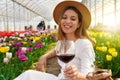 Relaxed beautiful woman enjoying a glass of red wine between tulips on spring time Royalty Free Stock Photo