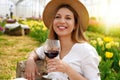 Relaxed beautiful woman enjoying a glass of red wine between tulips on spring time Royalty Free Stock Photo