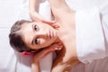 Relaxed beautiful woman lying on her back and looking at camera during massage treatment closeup portrait Royalty Free Stock Photo