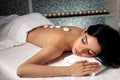 Woman with stones on her back in spa salon. Royalty Free Stock Photo