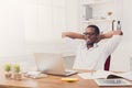 Relaxed black businessman with laptop in modern white office Royalty Free Stock Photo