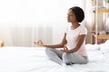 Relaxed black woman sitting on bed and meditating Royalty Free Stock Photo