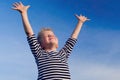 Relaxed boy breathing fresh air raising arms over blue sky at summer. Dreaming, freedom and traveling concept Royalty Free Stock Photo