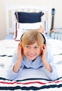 Relaxed boy listening music lying down on bed Royalty Free Stock Photo