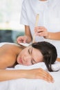 Relaxed brunette getting an ear candling treatment Royalty Free Stock Photo