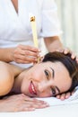 Relaxed brunette getting an ear candling treatment Royalty Free Stock Photo