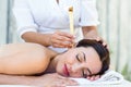 Relaxed brunette getting an ear candling treatment Royalty Free Stock Photo