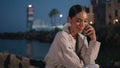 Relaxed brunette speaking mobile phone at evening waterfront close up. Royalty Free Stock Photo