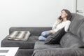 Relaxed Brunette Talking on Cellphone While Sitting on Sofa